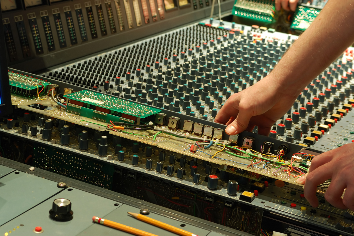 mixing console repair technician repairing audio console
